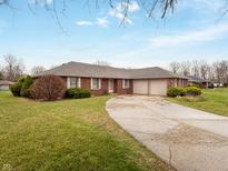 Charming brick home featuring an attached two-car garage and a well-maintained front yard with mature landscaping at 4506 Winter Dr, Anderson, IN 46012