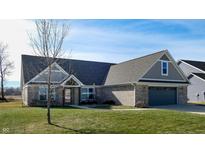 Brick ranch home with gray roof, attached garage, and landscaped lawn at 4667 W Meadows Ln, New Palestine, IN 46163