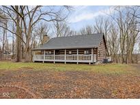 Rustic log cabin with wrap-around porch and wooded lot at 1084 Chipmunk Ln, Pendleton, IN 46064