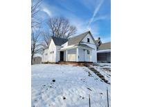 White house with front porch, steps, and snowy yard at 1826 Tallman Ave, Indianapolis, IN 46218