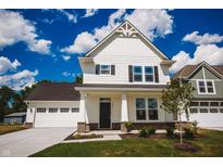 Charming two-story home with white siding, a well-manicured lawn, and an attached garage under a bright blue sky at 1841 Luther St, Indianapolis, IN 46203