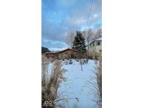 Cozy ranch home with snowy front yard and mature plantings at 2230 E 75Th St, Indianapolis, IN 46240