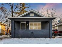 Brick house with gray paint, front porch, and snowy yard at 3929 E 30Th St, Indianapolis, IN 46218