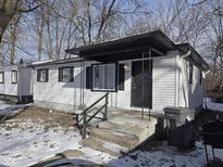 A charming home boasts a covered front porch and fresh white siding, promising cozy curb appeal at 3951 N Pasadena St, Indianapolis, IN 46226