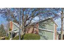 Brick and green-sided home with mature trees and landscaping at 8176 Foxchase Cir, Indianapolis, IN 46256