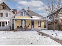 Yellow Victorian home with front porch and snow-covered lawn at 127 S Butler Ave, Indianapolis, IN 46219