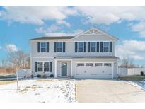 Two-story house with gray siding, a two-car garage, and a snow-covered front yard at 13781 N Rising Sun E Cir, Camby, IN 46113