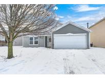 Gray house with white garage door, snow covered yard, and tree in front at 2997 W Longbranch Dr, Monrovia, IN 46157
