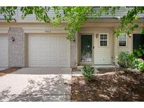 Charming townhome featuring an attached garage, a welcoming front door, and landscaped grounds at 7042 Tyler Ln, Indianapolis, IN 46217
