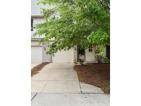 Attractive townhouse featuring an attached garage, well-maintained landscaping, and a welcoming entrance at 7042 Tyler Ln, Indianapolis, IN 46217
