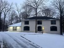 Two-story house with white brick exterior, black windows, and a snow-covered lawn at 7811 Providence Cir, Indianapolis, IN 46250