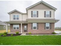 Charming two-story home featuring a brick facade, landscaped yard, and welcoming front porch at 7824 Magnolia St, New Palestine, IN 46163