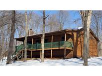 Wooden home with wrap around porch sits on a snowy lot at 7887 Elk Dr, Nineveh, IN 46164