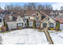 Luxury home with stone accents and landscaped yard, snow covered at 7928 Stonebriar Way, Indianapolis, IN 46259