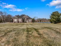 Brick house with large yard, attached garage, and pond view at 8152 Cottonwood Dr, Martinsville, IN 46151