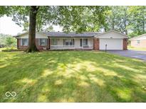 Brick ranch house with a spacious front yard and attached garage at 9876 Woodbriar Ln, Carmel, IN 46280