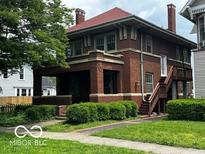 Charming two-story brick home with a covered front porch and well-maintained landscaping at 1023 Franklin St, Columbus, IN 47201