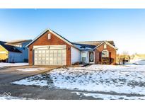 Brick ranch home with attached garage and snow-covered front yard at 1292 Bearsden Cir, Avon, IN 46123