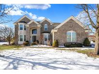 Brick two-story house with a landscaped yard and snow-covered lawn at 13678 Cunningham Dr, Carmel, IN 46074