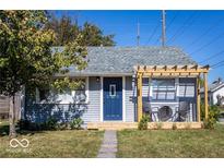 Charming bungalow with gray siding, blue door, and pergola-covered deck at 1654 Iowa St, Indianapolis, IN 46203