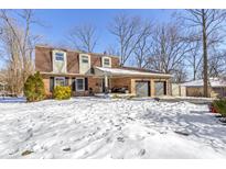 Snow-covered front yard of charming brick house with attached garage at 18 Round Hill Ct, Danville, IN 46122