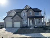 Elegant two-story home featuring a two-car garage, gray brick, stone accents, and a welcoming front porch at 19962 Stone Side Ct, Westfield, IN 46074