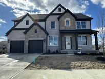 Two-story home with gray brick, black trim, gabled roof, covered entry, and two-car garage at 19962 Stone Side Ct, Westfield, IN 46074