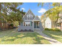 Charming gray house with green door, landscaped lawn, and walkway at 326 N Arlington Ave, Indianapolis, IN 46219