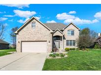 Charming two-story brick home featuring an attached two-car garage and a well-manicured front yard at 386 White Oak Ln, Greenwood, IN 46142