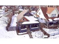Aerial view of a charming house with a gray exterior and snow-covered yard at 416 N Grant Ave, Indianapolis, IN 46201
