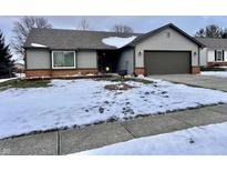 Gray sided ranch home with a snow covered front yard and attached garage at 545 Lake Crossing Ln, Franklin, IN 46131