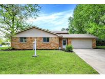 Charming brick home featuring a well-maintained lawn and attached two-car garage at 9157 Neptune Dr, Indianapolis, IN 46229