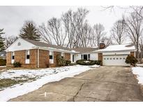 Brick ranch house with attached garage and snow-covered landscaping at 9281 N Temple Ave, Indianapolis, IN 46240