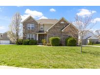 Charming two-story brick home with lush green lawn and blossoming trees, offering curb appeal at 11383 Sea Side Ct, Fishers, IN 46040