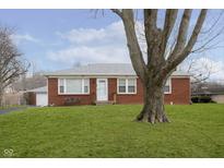 Brick ranch house with a large front yard and mature tree at 1215 N Shortridge Rd, Indianapolis, IN 46219