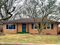Charming single-story brick home with a well-manicured lawn and decorative metal porch accents at 1350 N Graham Ave, Indianapolis, IN 46219