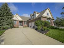 Charming brick home featuring a three-car garage, manicured lawn, and welcoming front entrance at 16395 La Paloma Ct, Noblesville, IN 46060