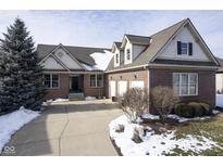 Brick home with 3-car garage, snow-covered landscaping, and a spacious driveway at 16395 La Paloma Ct, Noblesville, IN 46060