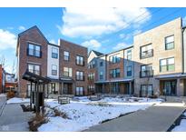 Modern brick townhouses with a shared courtyard, snow on the ground, and a sunny winter day at 1852 Mcquat Pl, Indianapolis, IN 46202