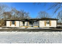 White brick ranch house with black accents, wooden shutters, and a front porch at 4305 Five Points Rd, Indianapolis, IN 46239