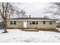 Brick ranch home with a snow-covered yard at 8415 E 10Th St, Indianapolis, IN 46219