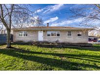 Charming single-story home featuring a stone facade, bright white door, and a well-maintained lawn at 8415 E 10Th St, Indianapolis, IN 46219