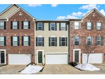 Brick front exterior of three-story townhouses with attached garages at 9022 Ramapo Dr, Fishers, IN 46038