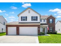 Inviting two-story home featuring a three-car garage and a well-manicured lawn at 977 Capricorn Dr, Franklin, IN 46131