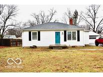 Cute ranch home with teal door, landscaping, and detached garage at 120 Hoss Rd, Indianapolis, IN 46217