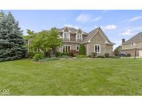 Charming two-story brick home with landscaped yard and inviting curb appeal on a sunny day at 14832 Sulky Way, Carmel, IN 46032