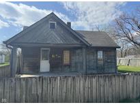A rustic wood house with boarded windows, needing repairs at 1520 N Bancroft St, Indianapolis, IN 46201