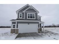 Charming two-story home with gray siding and a large two-car garage with a snow-covered lawn at 2310 Marjorie Way, Shelbyville, IN 46176