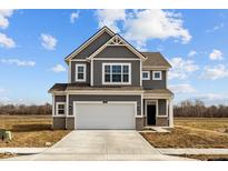 Two-story home featuring a two-car garage, and gray siding with white trim, set against a partly cloudy blue sky at 2310 Marjorie Way, Shelbyville, IN 46176
