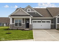 Charming home featuring a two-car garage, stone accents, and well-manicured lawn at 3617 Wrangler Dr, Bargersville, IN 46106
